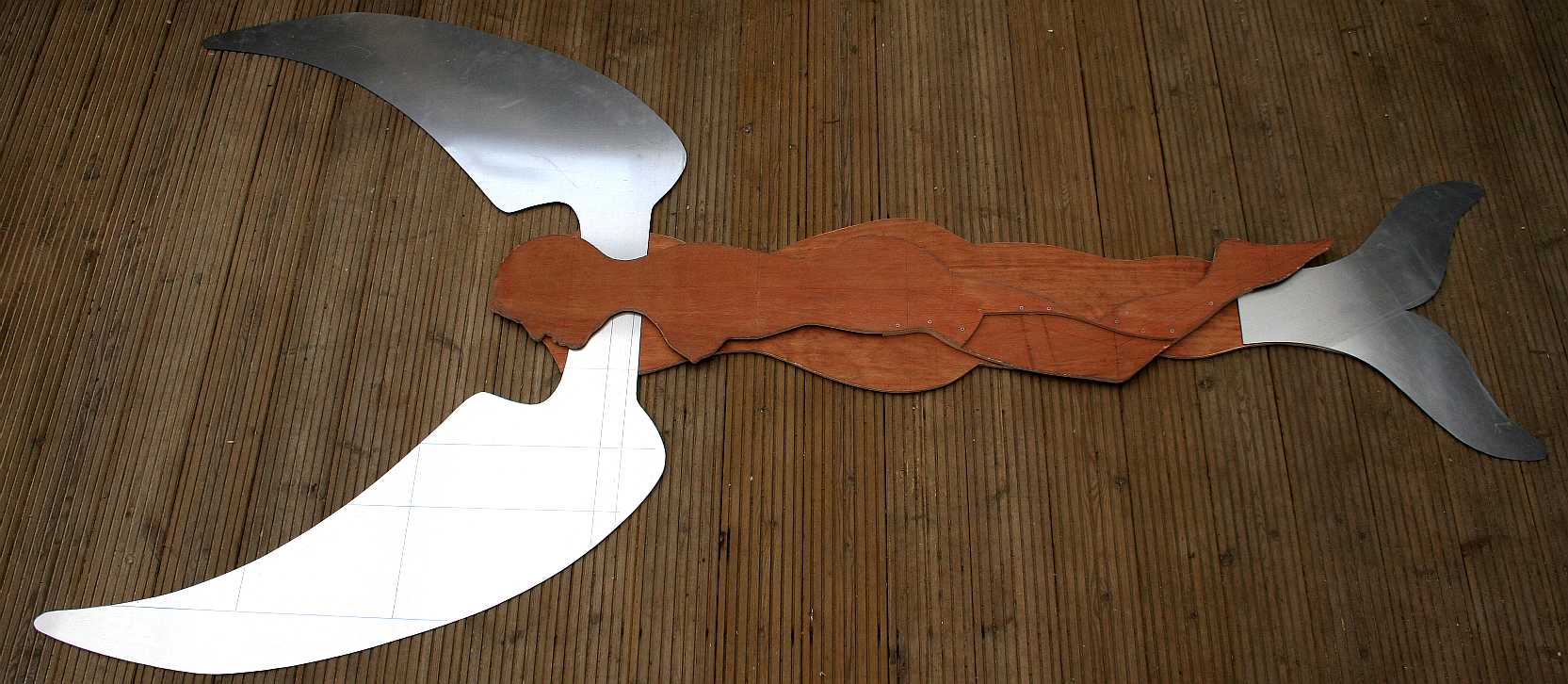 The aluminium wings and tail are cut from sheet metal to complete the set. Now begins the job of joining them all together. Plywood is made by bonding thin layers of wood together with the grain alternating in direction with each layer. By this means a flat board can be made that is very strong. Copyright  photograph.