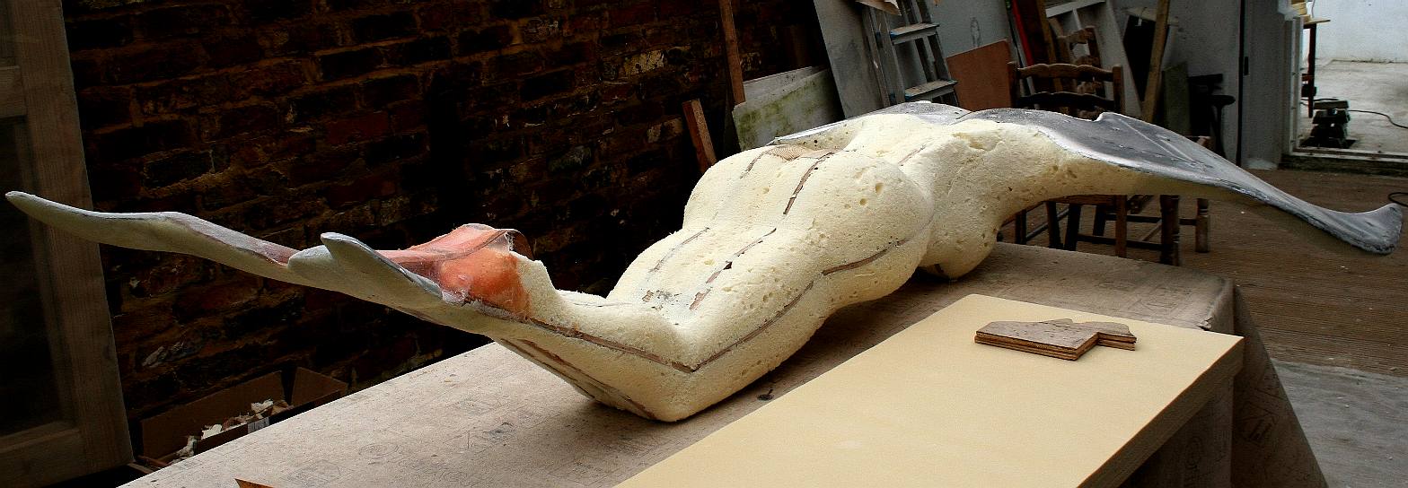 The upper (outer) wing surface is next for a coat of epoxy and woven glass cloth. The rivets and wood screws are ground down and the aluminium must be keyed for a good bond. The artist is at this stage working on the head drawings and considering the best angle where the statue is mounted at a different angle to a figurehead. Copyright  photograph Cleaner Ocean Foundation Ltd. All rights reserved.